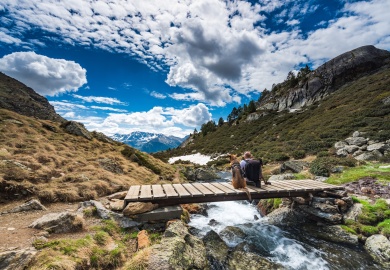 Wanderluster hiker sitting with dog in mountains