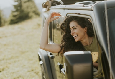 Young woman enjoying freedom in terrain vehicle on a sunny day