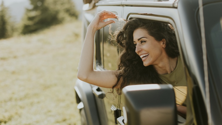 Young woman enjoying freedom in terrain vehicle on a sunny day