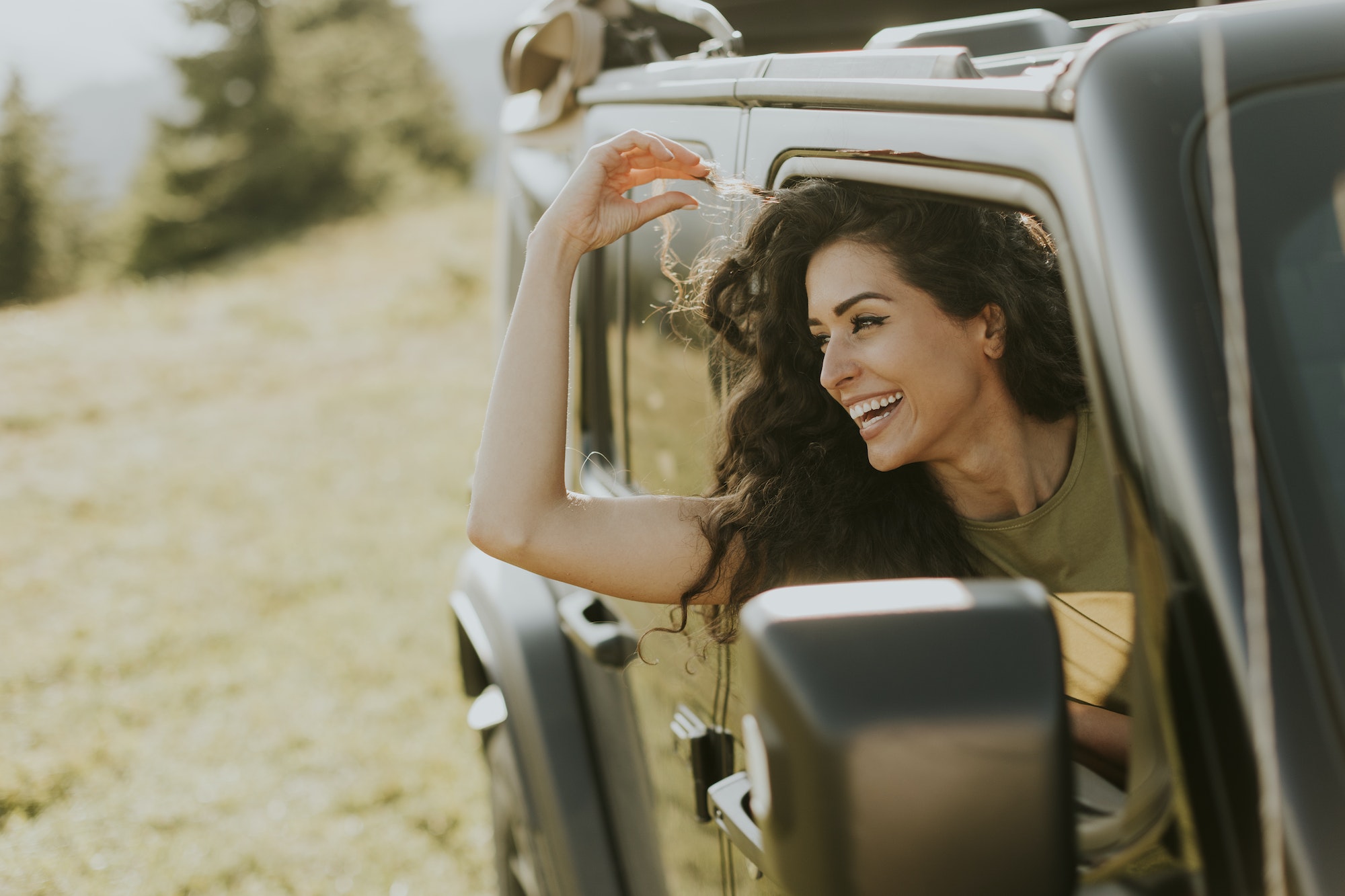 Young woman enjoying freedom in terrain vehicle on a sunny day